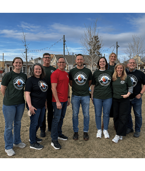 Grupo de adultos vestindo camisetas com logotipo em ambiente externo